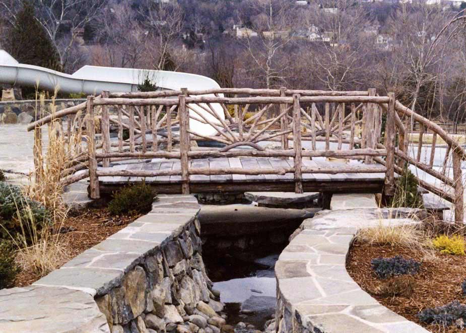 Rustic bridge custom built using cedar trees and branches titled the Murphy Bridge