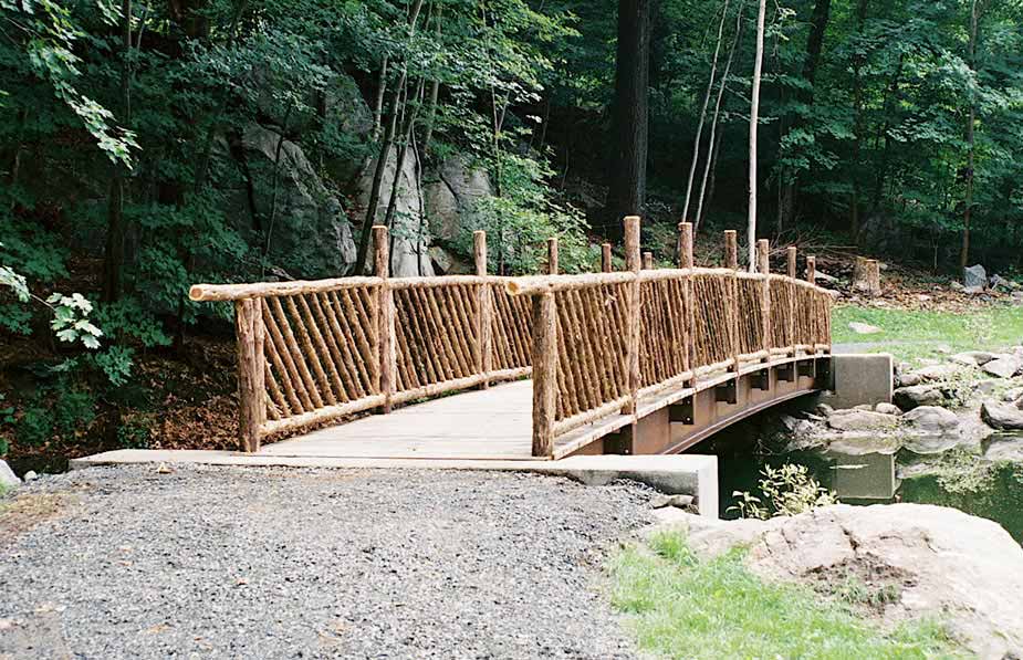 Rustic bridge railings custom built using cedar trees and branches titled the Westchester Bridge