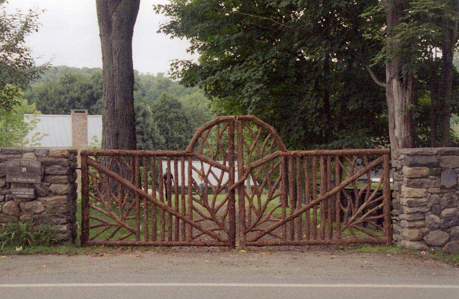 Driveway gates built in the rustic style using logs and branches titled Salem Gates