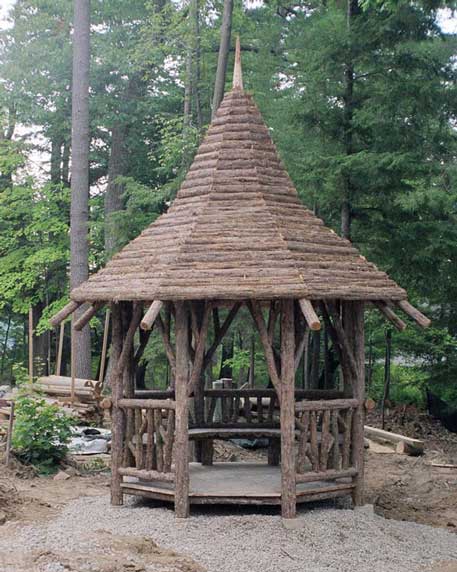 Rustic garden pavilion with a high peaked roof built using bark-on trees and branches titled the Lake George Gazebo