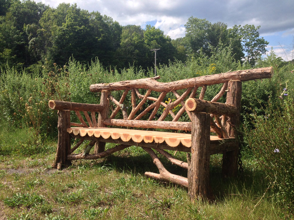 Outdoor park bench built in the rustic style using logs and branches titled the Burroughs