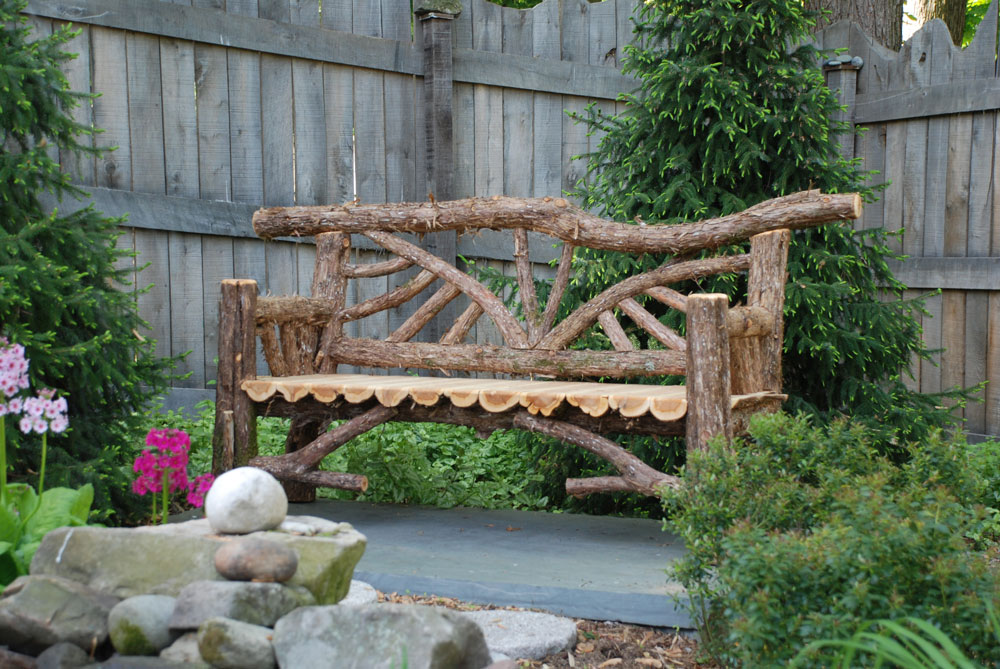 Outdoor rustic garden bench built using bark-on trees and branches titled the Butterfly